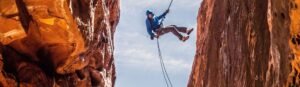 Climber handing between two cliffs from a safety rope